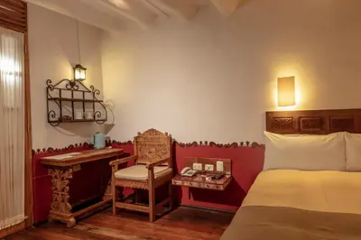 a bedroom with a bed and a chair and a desk at Tambo del Arriero Hotel Boutique in Cusco