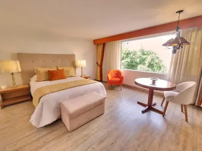 a bedroom with a bed and a table and a window at Antara Hotel & Suites - Miraflores in Lima