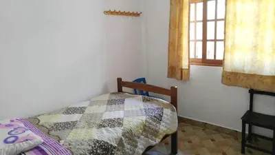 a bedroom with a quilt on a bed and a window at Casa de Campo Belén - Lunahuaná in Lunahuaná