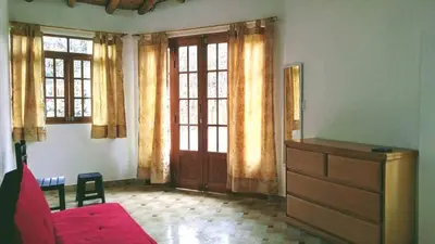 a living room with a red couch and a dresser at Casa de Campo Belén - Lunahuaná in Lunahuaná