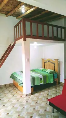 two beds in a room with a loft at Casa de Campo Belén - Lunahuaná in Lunahuaná