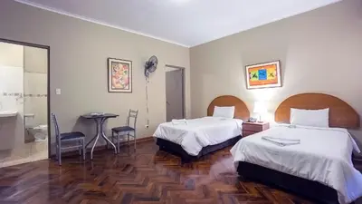 a hotel room with two beds and a table at Suites Larco 656 Miraflores Lima in Lima