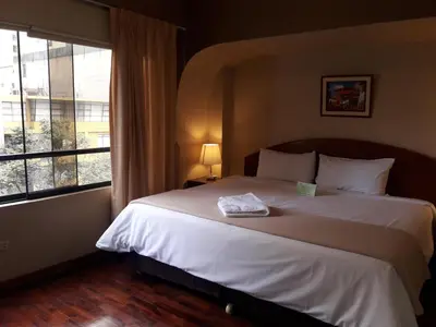 a bedroom with a large bed and a large window at Suites Larco 656 Miraflores Lima in Lima