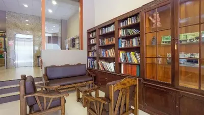 a library with a chair and bookshelves at Suites Larco 656 Miraflores Lima in Lima
