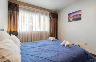 a bedroom with a blue bed with towels on it at Apartamento en el centro Cusco Inlove in Cusco