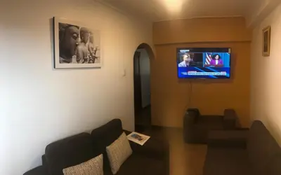 a living room with a couch and a flat screen tv at Apartamento en el centro Cusco Inlove in Cusco