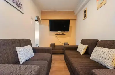 a living room with two couches and a flat screen tv at Apartamento en el centro Cusco Inlove in Cusco