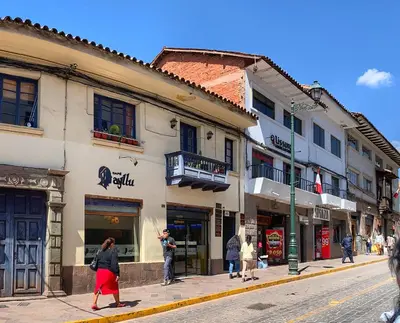 a woman walking down a street in front of a building at Excelente ubicación en el Centro Cusco Inlove in Cusco