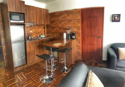a kitchen with a counter and a bar with stools at Excelente ubicación en el Centro Cusco Inlove in Cusco