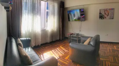 a living room with two leather chairs and a television at Excelente ubicación en el Centro Cusco Inlove in Cusco