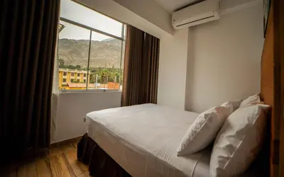 a bedroom with a bed and a large window at El Encanto in Lunahuaná