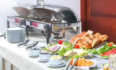 a buffet of food on a table with plates of food at Golden Sunrise Machupicchu in Machu Picchu