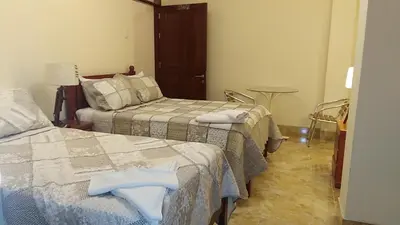 a hotel room with two beds and a table at Hotel Elizabeth Hoss in Sayán