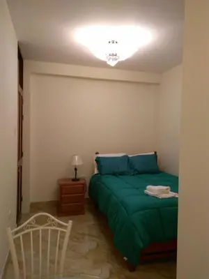 a bedroom with a green bed and a chair at Hotel Elizabeth Hoss in Sayán