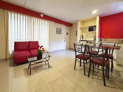 a living room with a red couch and a table at Casa Fanning Hotel in Lima