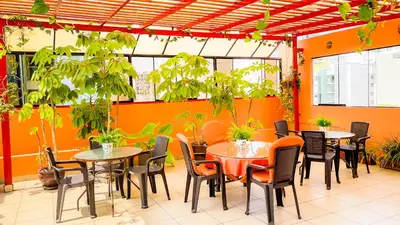 a restaurant with tables and chairs and plants at Casa Fanning Hotel in Lima