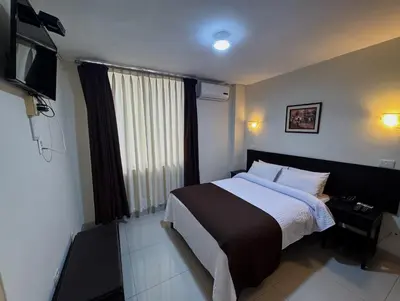 a hotel room with a bed and a television at Casa Fanning Hotel in Lima
