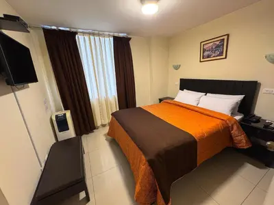 a hotel room with a bed and a flat screen tv at Casa Fanning Hotel in Lima
