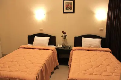 a hotel room with two beds and a table with flowers at Casa Fanning Hotel in Lima