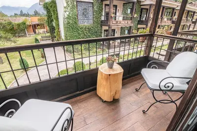 a balcony with two chairs and a table with a view at Sonesta Posadas del Inca - Valle Sagrado Yucay Urubamba in Urubamba