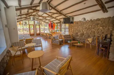 a room with tables and chairs and a stone wall at Tierra Viva Valle Sagrado Hotel in Urubamba