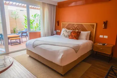 a bedroom with a large bed with an orange wall at qema Lima in Lima
