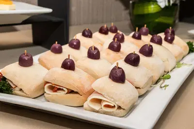 a white plate with a bunch of sandwiches with cherries on them at Sonesta Hotel El Olivar in Lima