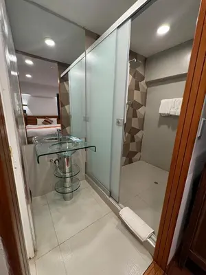 a bathroom with a glass shower and a sink at Waman Qorikancha in Cusco