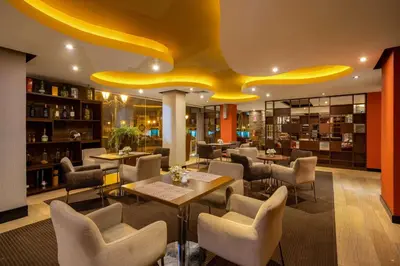 a restaurant with tables and chairs and a yellow ceiling at Sonesta Hotel Cusco in Cusco