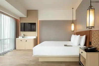 a bedroom with a large white bed and a kitchen at JW Marriott Hotel Lima in Lima