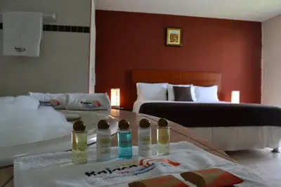 a bedroom with two beds and two bottles on a table at Kajaca Suite Hotel in Huacho