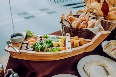a tray of food on a table with baskets of bread at Hotel Nobility in Lima