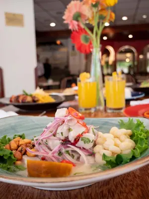 a plate of food on a table with a salad at Hotel Britania San Borja in Lima