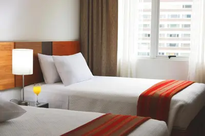 a hotel room with two beds and a window at San Agustin Exclusive in Lima
