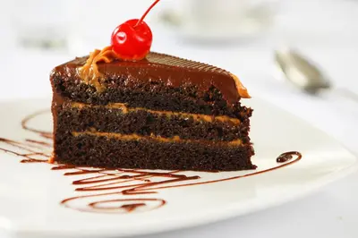 a piece of chocolate cake with a cherry on top at San Agustin Exclusive in Lima