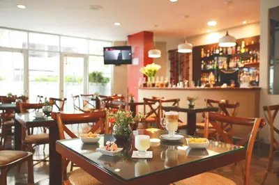 a restaurant with tables and chairs and a bar at San Agustin Exclusive in Lima