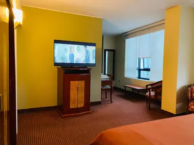 a hotel room with a flat screen tv on a yellow wall at Hotel Continental Lima in Lima