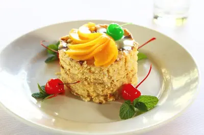 a piece of cake on a white plate with cherries at Hotel San Agustin Urubamba in Urubamba
