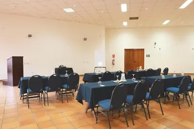 a conference room with blue tables and chairs in it at Hotel San Agustin Urubamba in Urubamba