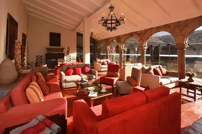 a large living room with red couches and chairs at San Agustin Monasterio de la Recoleta in Urubamba