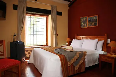 a bedroom with a large bed and a window at San Agustin Monasterio de la Recoleta in Urubamba
