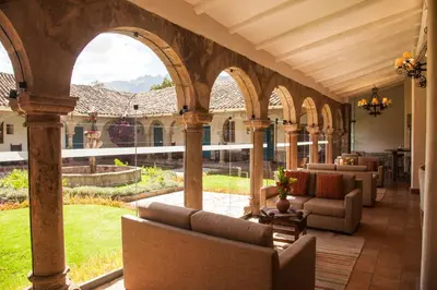 an outdoor patio with arches and chairs in a building at San Agustin Monasterio de la Recoleta in Urubamba