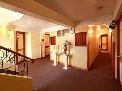 a room with a staircase and a table with a lamp at Hotel El Puma in Cusco