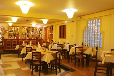 a restaurant with tables and chairs in a room at Hotel El Puma in Cusco
