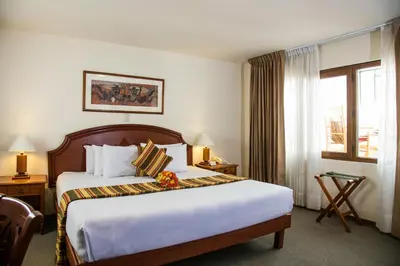 a hotel room with a large bed and a window at San Agustin Internacional in Cusco