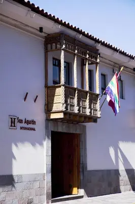 a building with a balcony and a flag at San Agustin Internacional in Cusco