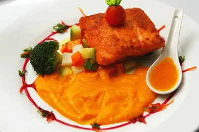 a plate of food with meat and vegetables and sauce at San Agustin El Dorado in Cusco