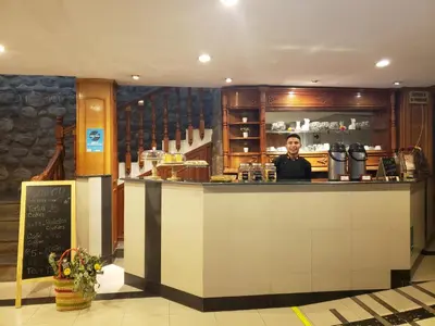 a man standing behind a counter in a restaurant at Hotel Sueños del Inka in Cusco