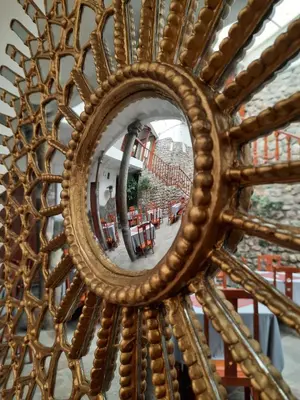 a mirror with a reflection of a table and chairs at Hotel Sueños del Inka in Cusco