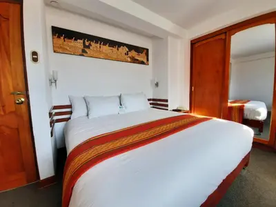 a bedroom with a large white bed in a room at Hotel Sueños del Inka in Cusco